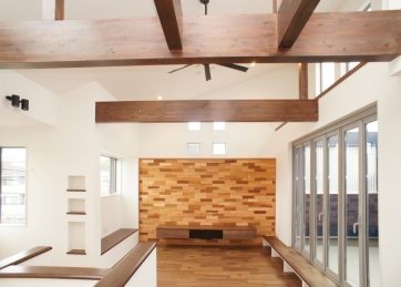 印象的な梁のある開放感を演出する勾配天井・ﾘﾋﾞﾝｸﾞｱｸｾﾝﾄｳｫｰﾙ：天龍木材バンピー（自然塗料塗装品）・TVﾎﾞｰﾄﾞ：EIDAI「ﾘﾋﾞﾝｸﾞｽﾃｰｼﾞﾌﾛｰﾄﾀｲﾌﾟ」（ｾﾋﾟｱﾌﾞﾗｳﾝ）うづくり調