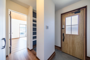 ゆったりとした造りの玄関。家に帰ってきてまずはホッと一息つく空間です。・玄関ドアYKK-AP「ヴェナートD30型」・玄関ポーチタイルLIXIL「ベスパ300角」・床材LIXIL「ラシッサDフロア耐水・ペット」：ナチュラルオーク・SIC可動棚可動棚板6枚ポリランバーダボレール付き：ホワイト・SICアクセントクロスリリカラ「XB-122」