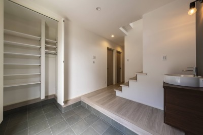 【２号棟】広々とした玄関スペースに手洗い洗面を設置。帰宅後すぐに手を洗える衛生的な動線と、間接照明が生み出す開放感のある空間デザインが、家族や来客を心地よく迎え入れます。