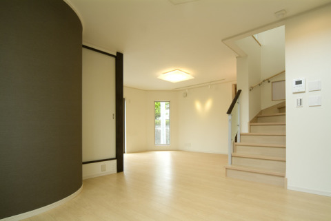 壁面を曲面にし、墨黒のダークカラーで落ち着いた空間を演出。・床材：東プラ「ハイパーフロアシストS」（メープル９・アクセントクロス：リリカラ「LV-3752」