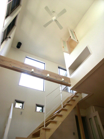 パドルファンのある開放的なＬＤＫ施工例。洋室にあるウェルカムウィンドーから下の様子も感じられる空間です。