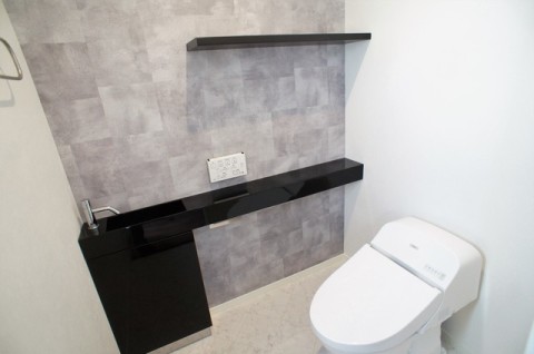 手洗いが設置されたトイレ。見せる収納として活躍できそうな棚も設置されており、便利です。