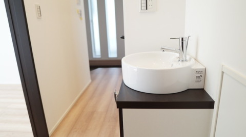 玄関より続く廊下に洗面台があります。コロナ禍の今、帰宅後にすぐ手洗いとうがいをでき、ウィルスや汚れを持ち込むことがありません・LIXIL「エスタ」（クリエダーク）W=600