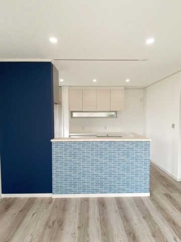 ブルーのタイルの壁紙を腰壁に使ったキッチン。爽やかな印象を演出しています。