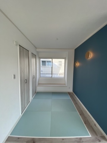 ネイビーの壁にウッド調の照明が印象的な畳コーナー。