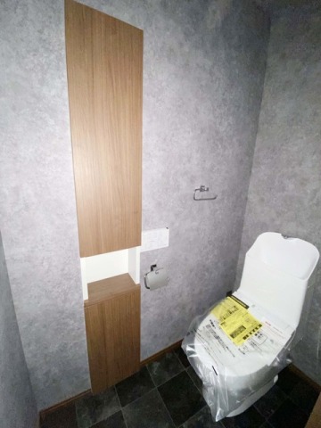 トイレタリーや買い置きのトイレットペーパーも収納できる物入が設置されているトイレ。・TOTO「CES9151」（ホワイト）・ペーパーホルダー：TOTO「YH409R」（シルバー）・タオルリング：TOTO「YT408R」（シルバー）・埋込収納：LIXIL「TSF-203U」「TSF204U」　　（クリエモカ）