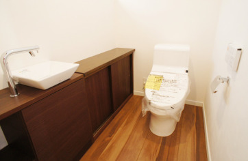 ゆったりとしたトイレ空間。収納もたっぷりとあり、お掃除道具や替えのトイレットペーパーなども収納でき、便利です。