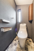 壁に造り付けの収納も設置されたトイレ。・LIXIL「ベーシア」（フチレス）（ピュアホワイト）・コーナー収納：TOTO「UGW180YS」（ダルブラウン）