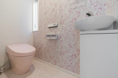 手洗いも設置されたトイレ。LIXIL「サティスＳタイプ」（ピンク）・手洗いキャビネット：LIXIL「YL-D201UCCAE-HP/WAW（自動水栓）
