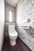 華やかなデザインの壁紙がリゾートを思わせるトイレ。〇TOTOウォシュレット一体型便器ZJ1（ホワイト）手洗なし（CES9150）・アクセントクロス：サンゲツ（TH-30607）・床材：サンゲツ（HM-4082）