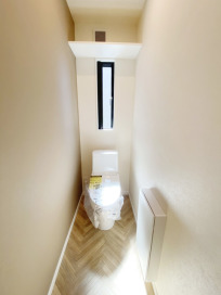 トイレットペーパーなどを収納できる場所が設置された使い勝手のよいトイレ。TOTO「CES9150」（ホワイト）壁面収納：TOTO「UGLD03」（ホワイト）