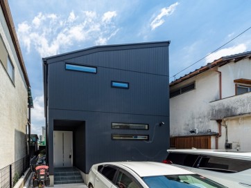 スタイリッシュさを強調したネイビーとブラックの組み合わせが個性的な外観デザイン・外壁材:(ベース)旭トステムAT-WALL15Pアーバンストライプ15P(カーサネイビーP)(アクセント)旭トステムAT-WALL15Pアーバンストライプ15P(カーサブラックP)
