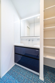 リネン類も上手に収納できる洗面室。爽やかなブルーの床が清潔感を感じさせます。・タカラスタンダード「エリシオ」（LNU2664CM）W=900・床材：フロアシートサンゲツ（CM-10213）