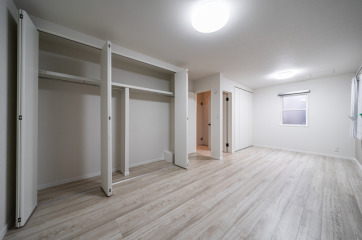 ２つのドアとクローゼットが２つ設置されている洋室。お子様の成長に合わせて、小さな時は大きな１つの空間として、大きくなったら、間仕切りで２部屋に分けて使用でき、便利です。・床材フローリングＬＩＸＩＬ「ラシッサＤフロア」耐水・ペット：チェスナット・ドアＥＩＤＡＩ「スキスムＳ」：単色ホワイト・収納折戸ＥＩＤＡＩ「スキスムＳ」レスフラットデザイン：単色ホワイト