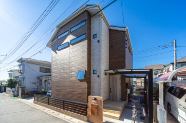 屋根付きの自転車置き場も設置された外観。グレージュと明るいブラウンのナチュラルな印象の外観です。・サイディングベース旭トステム「AT-WALL15P」ラスティウッドP:ラスティブラウンP・サィディングアクセント旭トステム「AT-WALL15P」レクタートP:レクターグレーP・玄関ドアYKKAP「ヴェナートD30」C05型:ココナッツチェリー・サッシYKKAP「エピソードNEO」LOW-Eガラスアルゴンガラス入り:外観カームブラック内観ホワイト